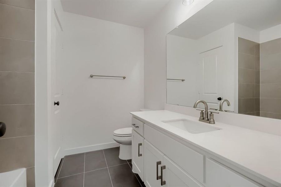 Bathroom featuring vanity and dark tile patterned floors