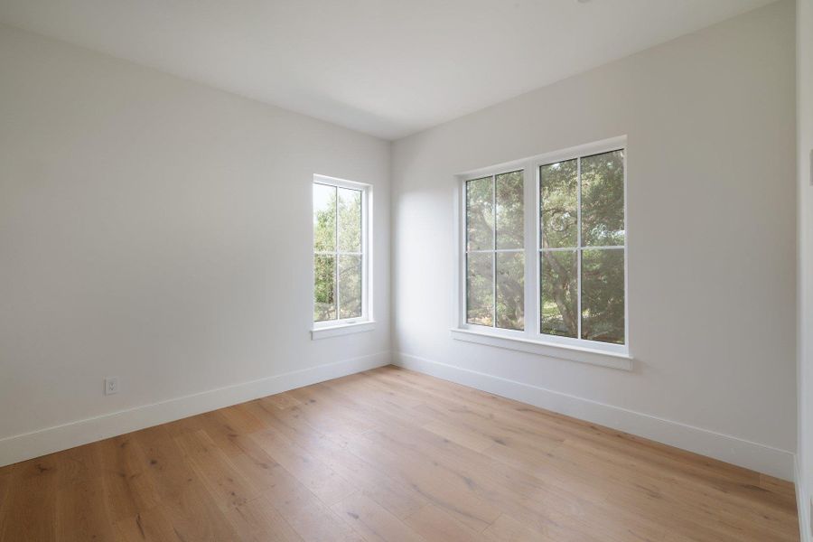 Secondary bedroom looks out into a heritage live oak.