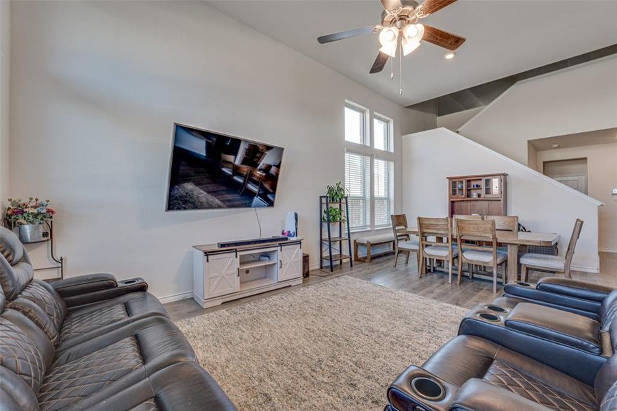 Living area with wood finished floors, a ceiling fan, and recessed lighting