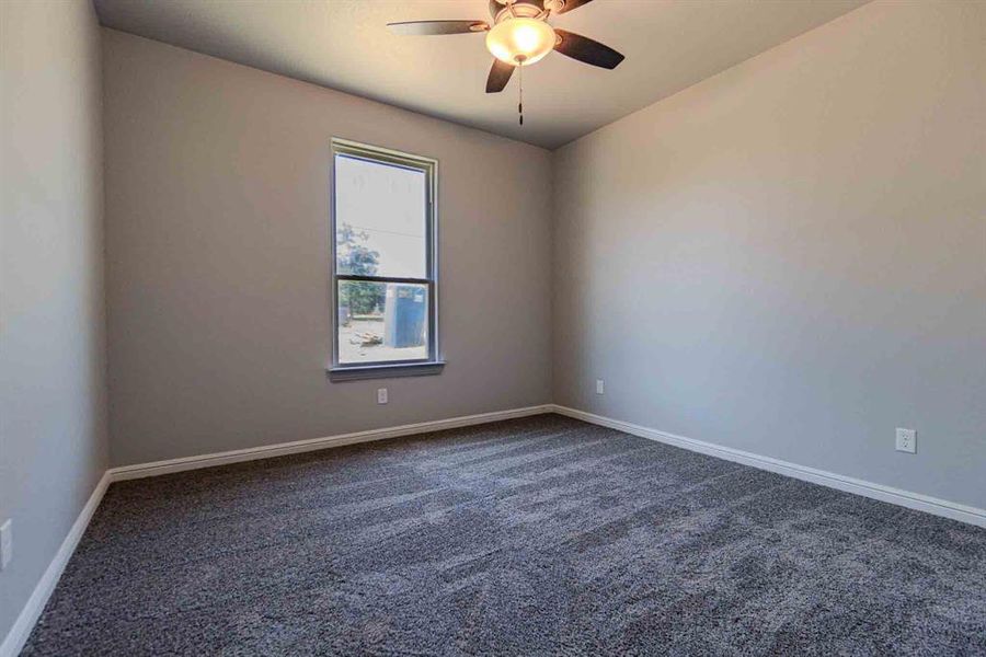 Unfurnished room with dark carpet and baseboards Unfurnished room with dark carpet and baseboards