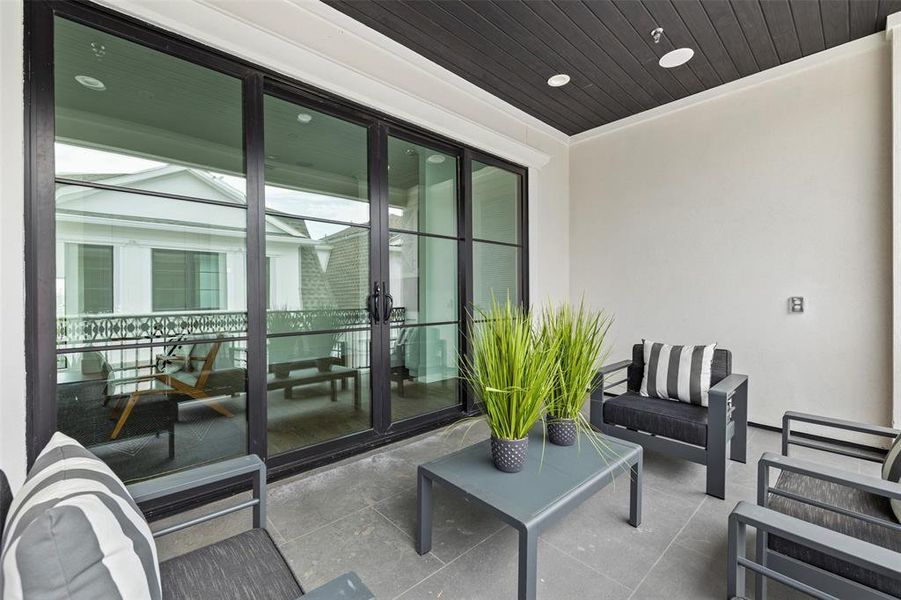 The sliding glass doors to the rooftop terrace encourage indoor/outdoor living, extending the large game room out to the covered patio for year-round enjoyment. Image of a previously completed home in the community.