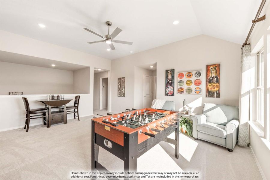 Game room with foosball table, seating area, ceiling fan, and dining space on carpet flooring