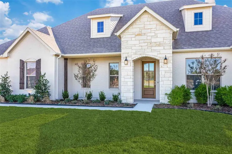 View of front of home featuring roof with shingles, stone siding, and a front lawn View of front of home featuring roof with shingles, stone siding, and a front lawn