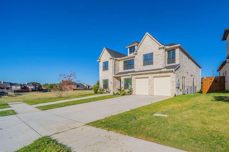 Traditional home with a garage, concrete driveway, and brick siding Traditional home with a garage, concrete driveway, and brick siding