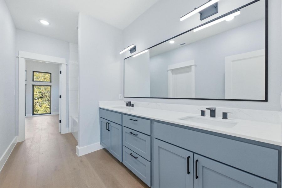 Bathroom with light wood-type flooring, double vanity, and recessed lighting Bathroom with light wood-type flooring, double vanity, and recessed lighting