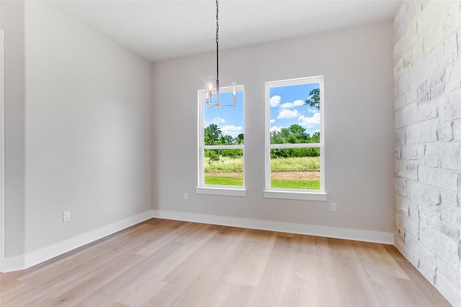Unfurnished dining area with light wood-type flooring and a chandelier