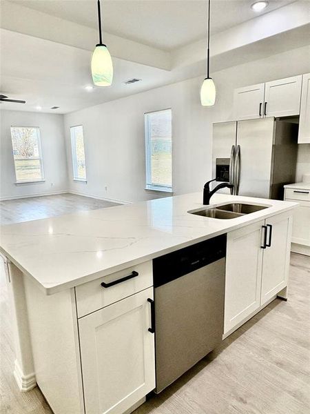 Kitchen with light wood-style flooring, white cabinets, pendant lighting, open floor plan, and recessed lighting