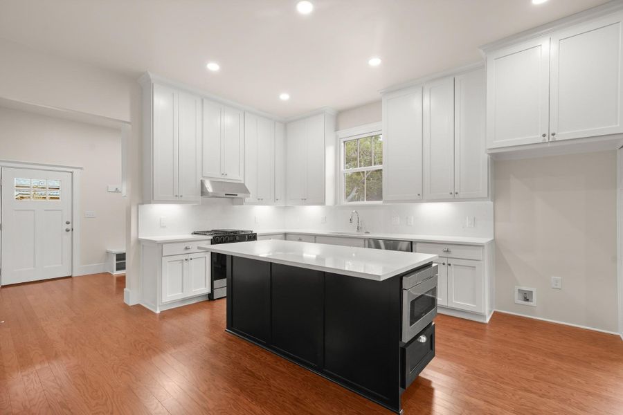 A well-equipped culinary space awaits with premium appliances and a central kitchen island. A well-equipped culinary space awaits with premium appliances and a central kitchen island.