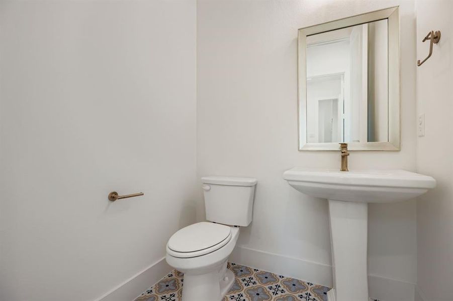 Half bathroom featuring baseboards and tile patterned flooring Half bathroom featuring baseboards and tile patterned flooring