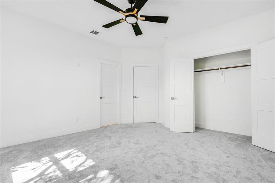 Unfurnished bedroom featuring light carpet, a closet, and ceiling fan