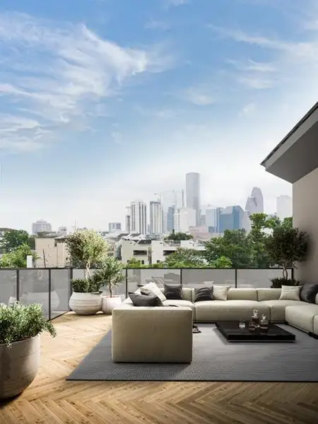 This photo showcases a modern rooftop terrace with a spacious seating area and lush planters. The space offers stunning downtown views of a Houston skyline under a clear blue sky, perfect for relaxation and entertaining. Virtually Staged. This photo showcases a modern rooftop terrace with a spacious seating area and lush planters. The space offers stunning downtown views of a Houston skyline under a clear blue sky, perfect for relaxation and entertaining. Virtually Staged.
