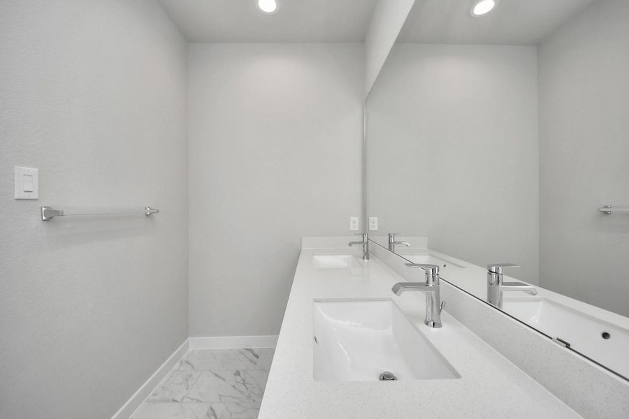 Elevate your daily routine at the elegant vanity, now equipped with double sinks, light countertops, modern hardware, and beautiful recessed lights. Sample photo of completed home with similar floor plan. Actual colors and selections may vary. Elevate your daily routine at the elegant vanity, now equipped with double sinks, light countertops, modern hardware, and beautiful recessed lights. Sample photo of completed home with similar floor plan. Actual colors and selections may vary.
