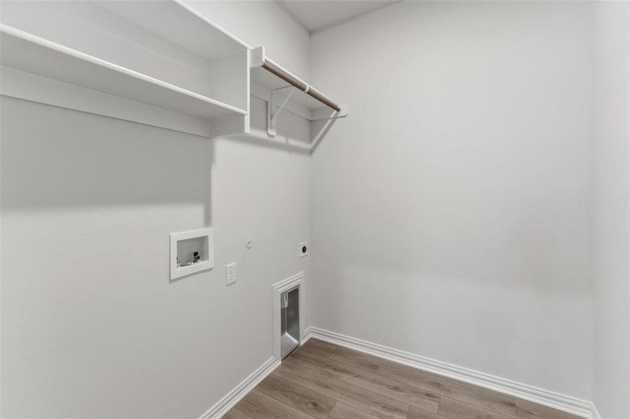 Laundry area featuring hookup for a gas dryer, light wood-style floors, hookup for an electric dryer, and hookup for a washing machine