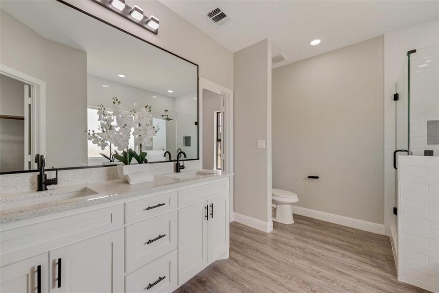 Bathroom with hardwood / wood-style flooring, dual vanity, and toilet