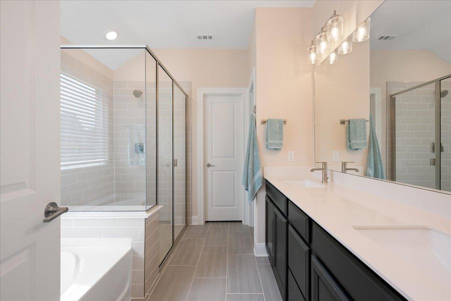 Primary bathroom with double vanity, separate garden tub and shower.