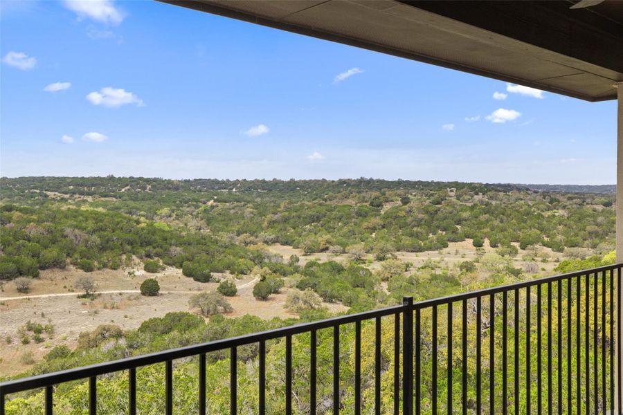 Balcony featuring a wooded view