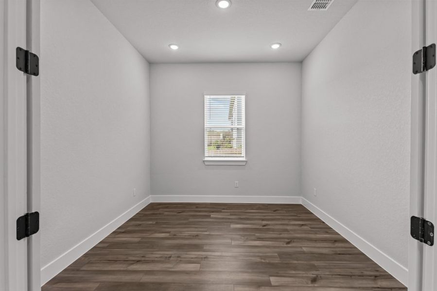 A room with a wood floor and white walls.