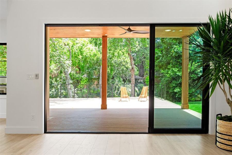 Doorway with plenty of natural light, light wood finished floors, and ceiling fan