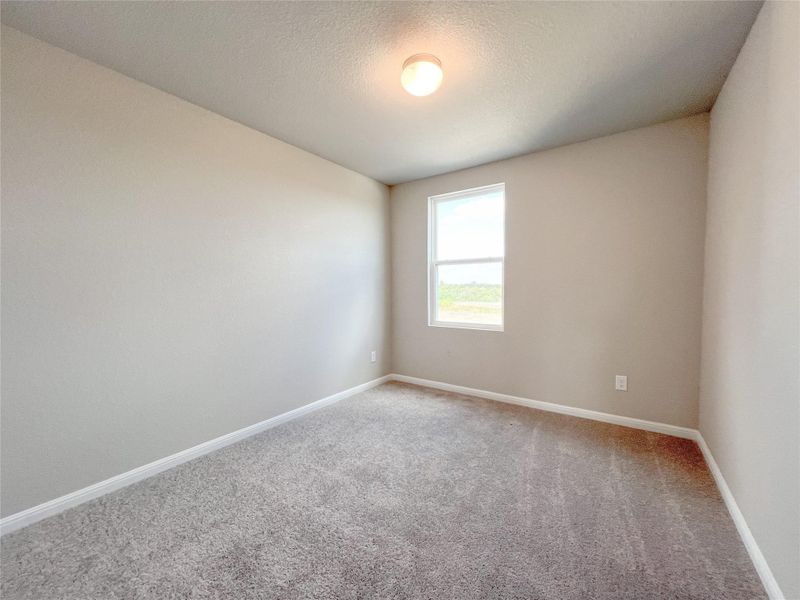 Empty room with carpet floors and a textured ceiling