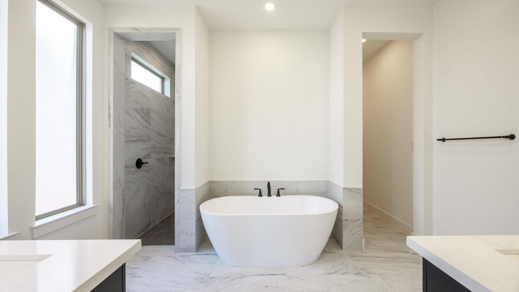 Full bathroom featuring vanity, a soaking tub, light marble finish floors, walk in shower, and tile walls Full bathroom featuring vanity, a soaking tub, light marble finish floors, walk in shower, and tile walls