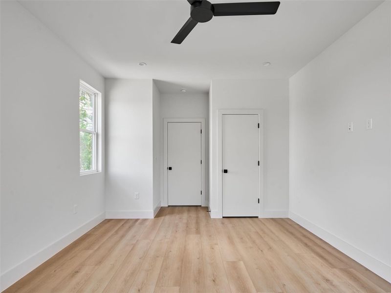 Empty room with light wood finished floors and ceiling fan Empty room with light wood finished floors and ceiling fan