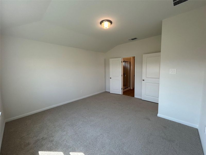 Unfurnished bedroom featuring vaulted ceiling and carpet floors Unfurnished bedroom featuring vaulted ceiling and carpet floors