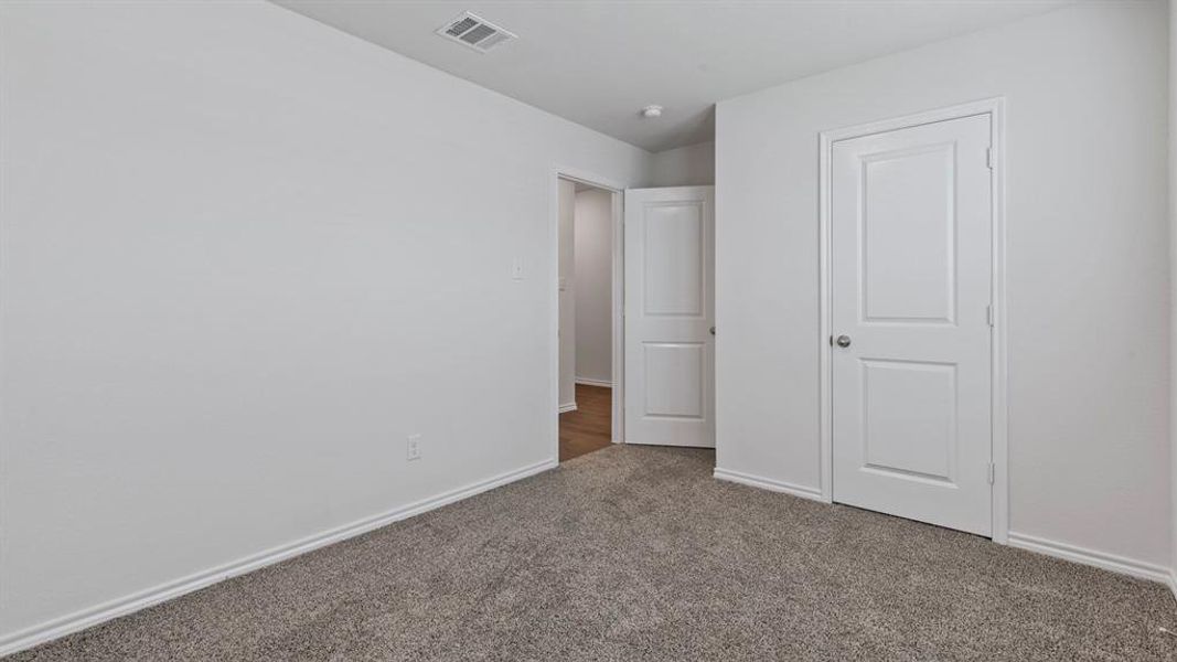 Unfurnished bedroom with carpet floors and baseboards