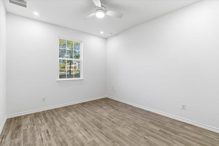 Empty room featuring light wood-style floors, ceiling fan, and recessed lighting