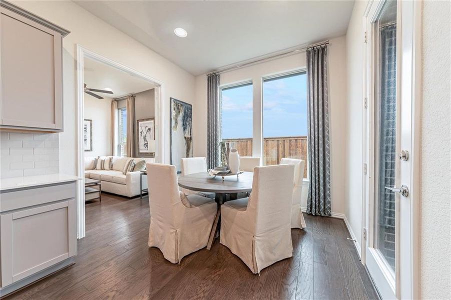 Bright dining area featuring wood-finish flooring, recessed lighting, and large windows