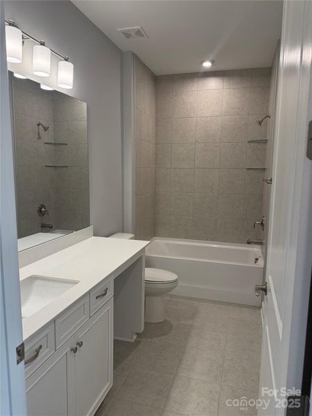 Hall bath has tile floor and tub surround.