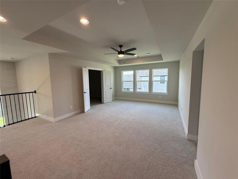 Unfurnished room featuring light colored carpet, a raised ceiling, a ceiling fan, and recessed lighting Unfurnished room featuring light colored carpet, a raised ceiling, a ceiling fan, and recessed lighting