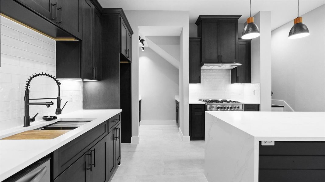 Cooking feels effortless with the sleek navy cabinetry, gold fixtures, and plenty of counter space to spread out and create. Cooking feels effortless with the sleek navy cabinetry, gold fixtures, and plenty of counter space to spread out and create.