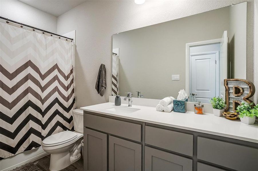 Secondary bathroom featuring toilet and vanity