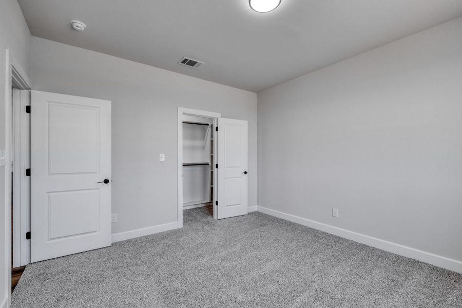 Unfurnished bedroom featuring carpet floors and baseboards