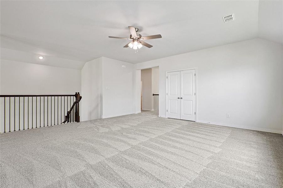 Carpeted spare room with lofted ceiling and ceiling fan