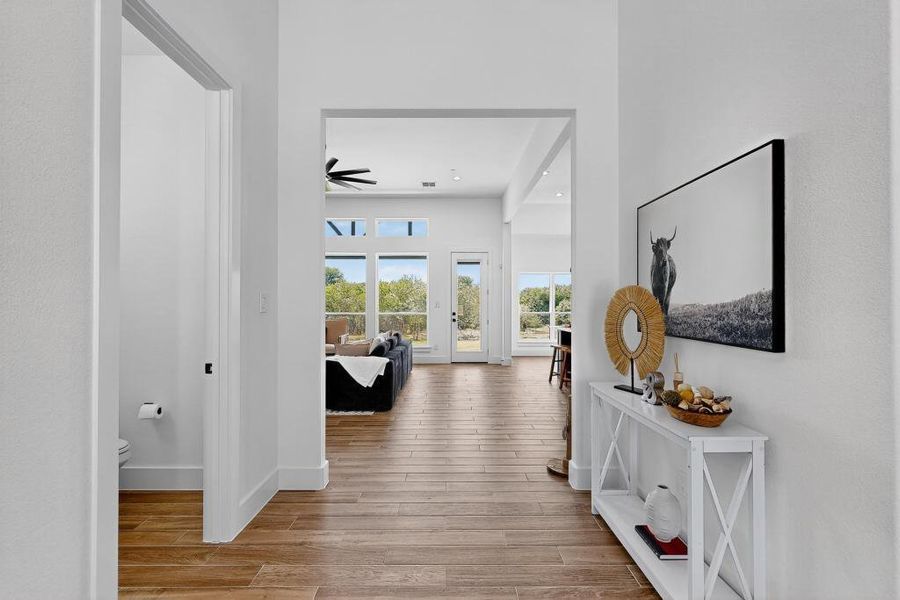 Hall with wood finished floors and recessed lighting