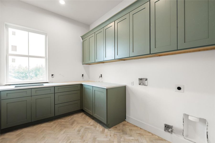 Utility room features beautiful herringbone tile, sage cabinetry, and sink. Utility room features beautiful herringbone tile, sage cabinetry, and sink.