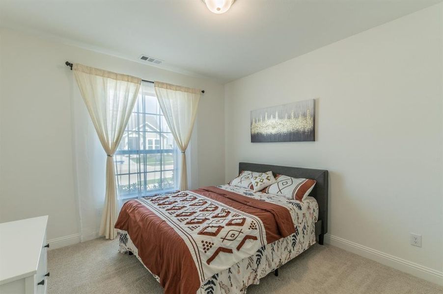 Carpeted room featuring a double-hung window with grid patterns, a ceiling-mounted light fixture, and crown molding