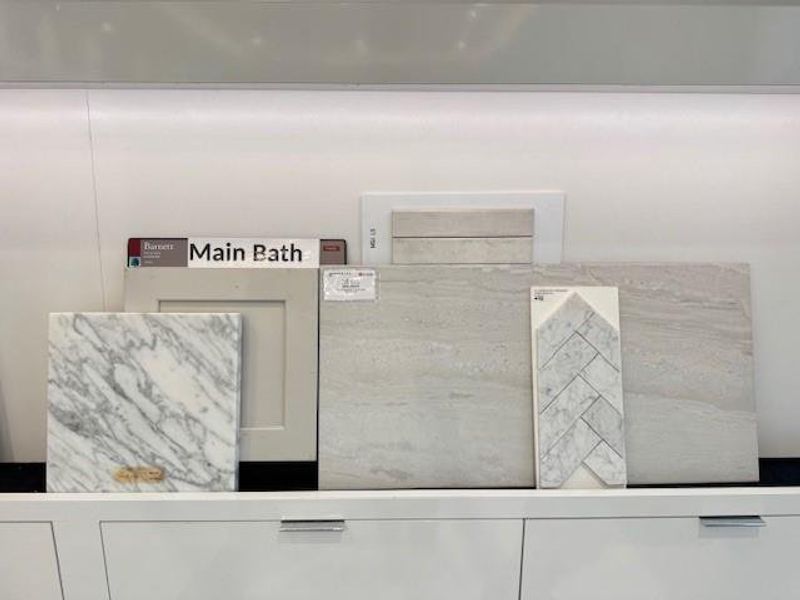 The main bathroom is elegant and subtle with quartz countertops paired with long, ceramic tile, and a herringbone tile on the shower floor.