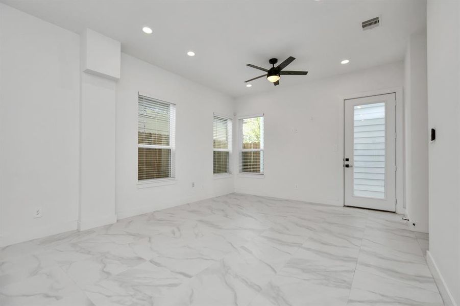 Revel in the contemporary charm of this spacious living area, accentuated by sleek tiled flooring and an open floor plan with an abundance of natural light.