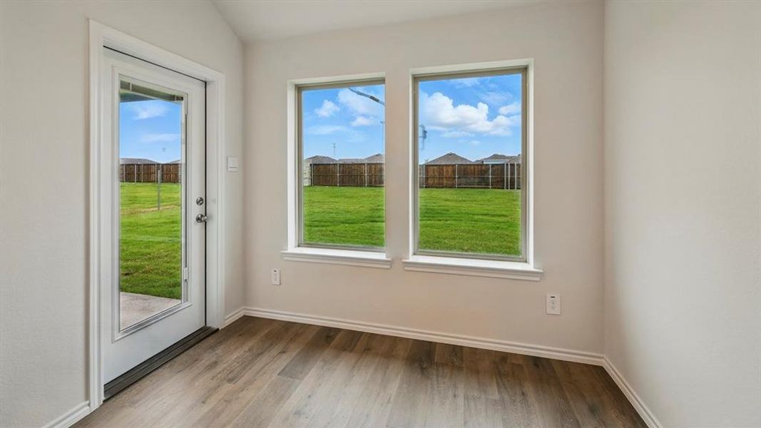 Doorway featuring wood finished floors and vaulted ceiling
