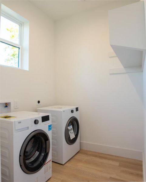 Laundry area featuring light hardwood / wood-style flooring and washer and dryer