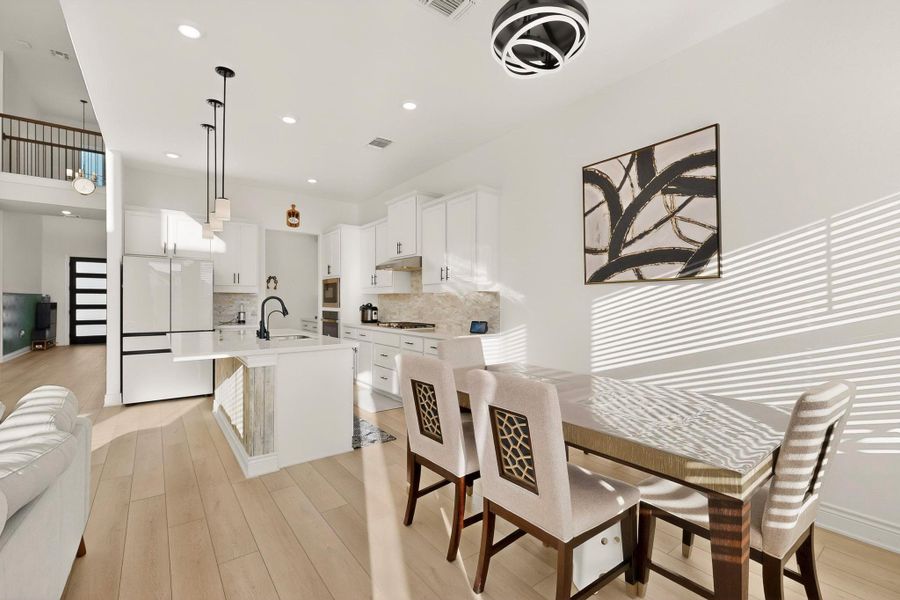Dining space with light wood finished floors and recessed lighting