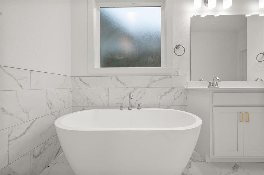 Primary bathroom with two sinks, tile floors, and a separate shower and tub.