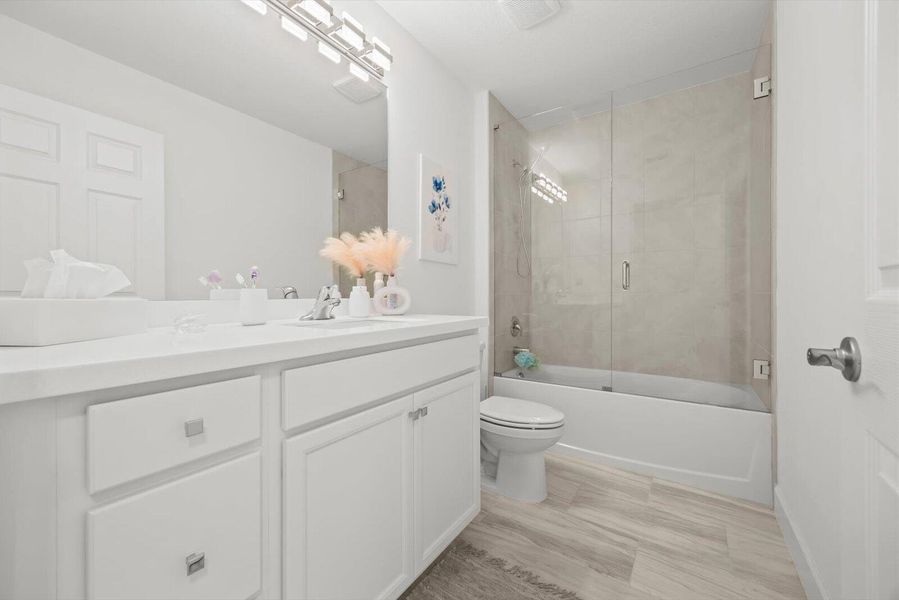 Stylish Second Bath with Designer Tile and Frameless Glass Enclosure