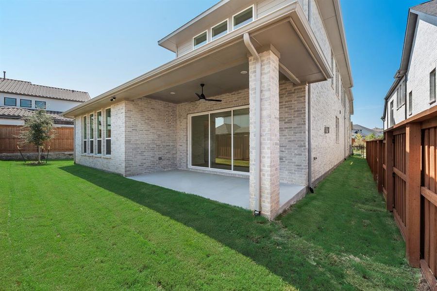Back of house featuring a ceiling fan, brick siding, a fenced backyard, and a patio