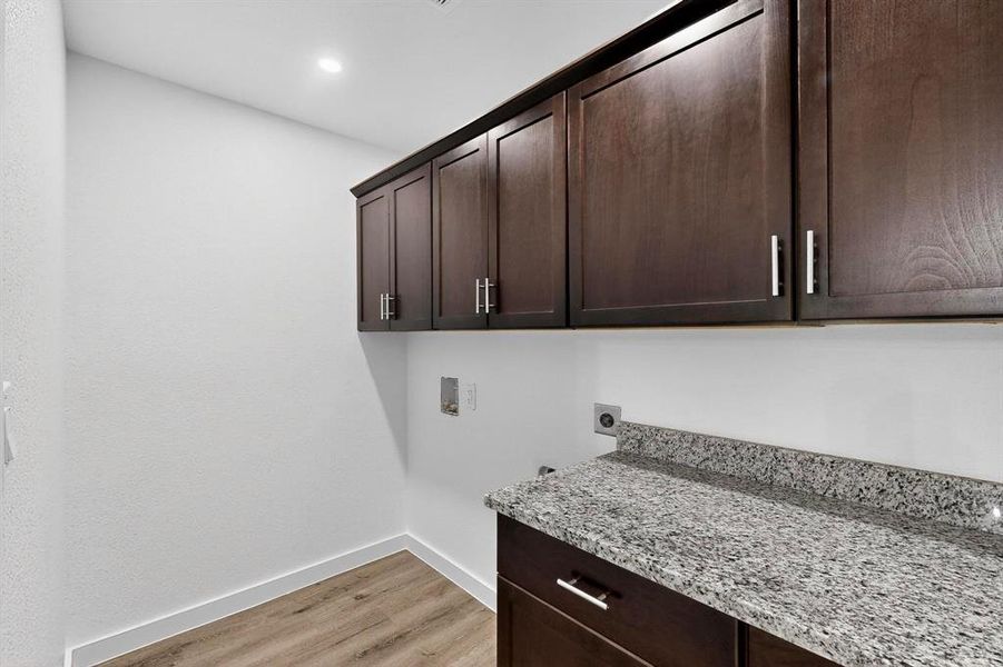 Laundry room with light wood finished floors, cabinet space, washer hookup, and hookup for an electric dryer