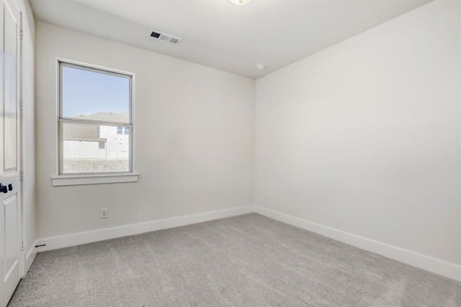 Spare room with baseboards and light colored carpet
