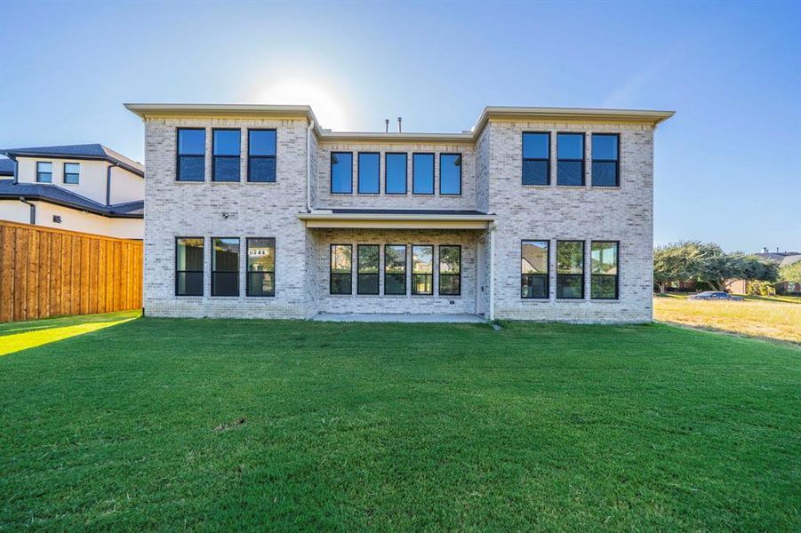 Rear view of house with brick siding, a yard, and a patio Rear view of house with brick siding, a yard, and a patio
