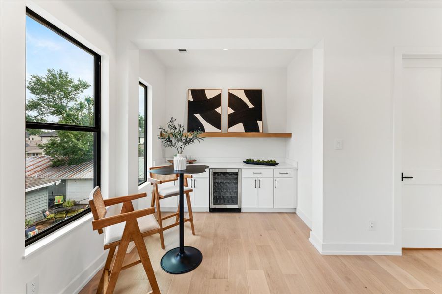 The game room features a built-in shelf for games and equipment, countertop surface for snacks and activities, plus a mini fridge for refreshments.  It also includes cabinets and drawers to neatly stow away items from view.